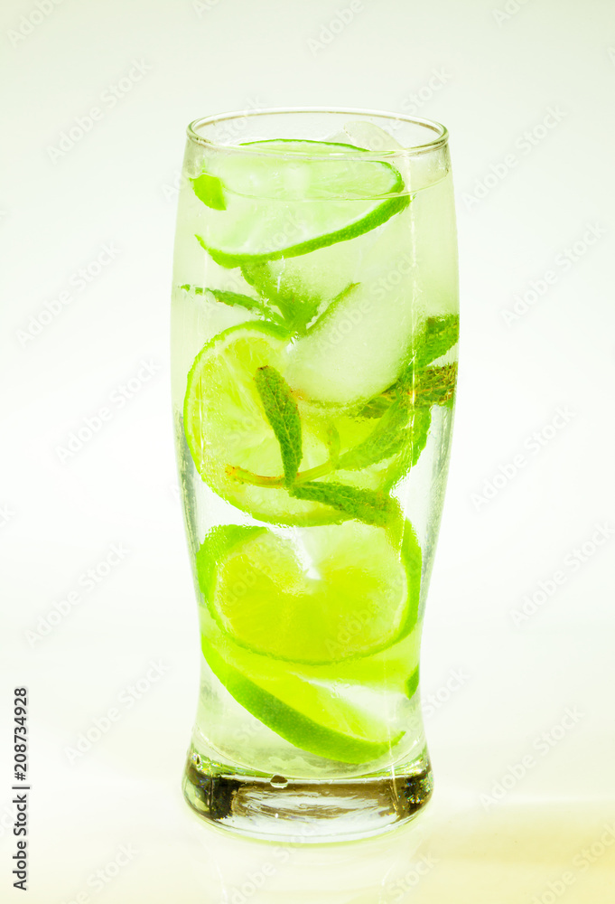 summer cold drink mojito lime and mint with ice and soda with drops on a glass on a white background summer cold drink mojito lime and mint with ice and soda with drops on a glass on a white background