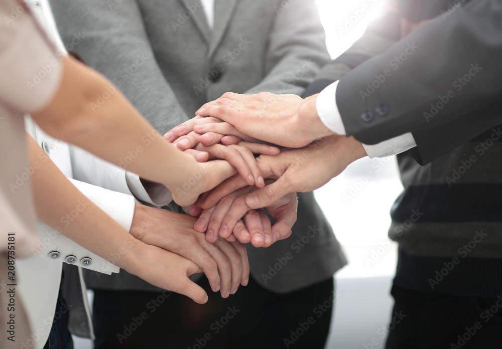 business colleagues with their hands stacked together business colleagues with their hands stacked together