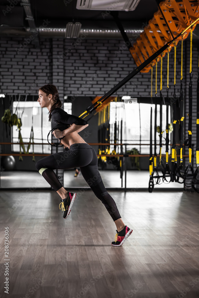Fitness woman training with trx fitness straps