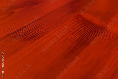 Abstract orange background from the varnished surface of the board, soft focus © savelov