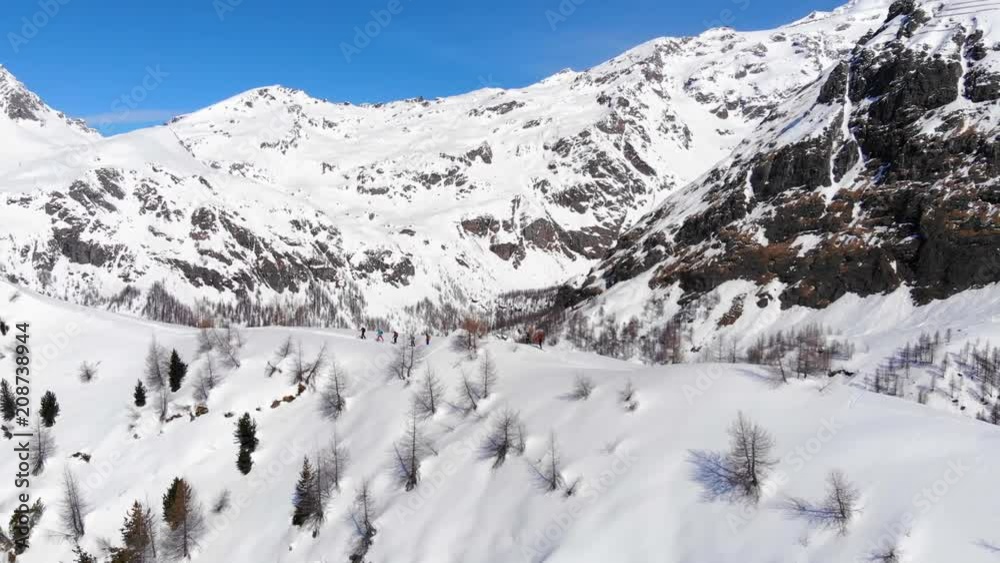 Aerial video. Group of ski touring on skin uphill in a line. Drone shot Ski touring in big mountains, beautiful landscape with high peaks in background. Ski touring in Alps and breath taking view Aerial video. Group of ski touring on skin uphill in a line. Drone shot Ski touring in big mountains, beautiful landscape with high peaks in background. Ski touring in Alps and breath taking view