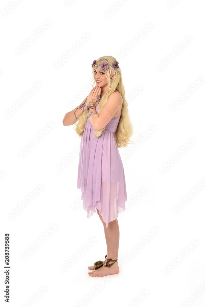 full length portrait of pretty blonde girl wearing purple fairy dress. standing pose, isolated on white studio background.