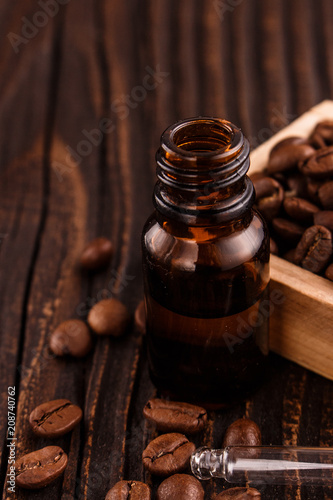 essential oil of coffee beans on a wooden background