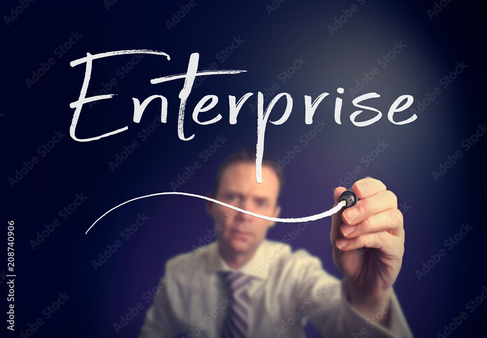 A businessman writing a Enterprise concept with a white pen on a clear screen. A businessman writing a Enterprise concept with a white pen on a clear screen.