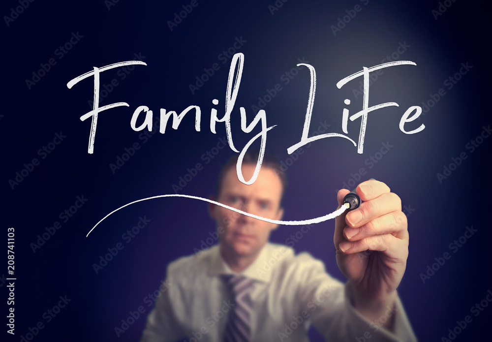 A businessman writing a Family Life concept with a white pen on a clear screen. A businessman writing a Family Life concept with a white pen on a clear screen.