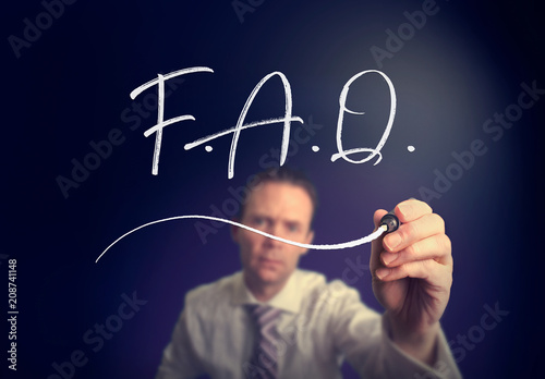 A businessman writing a F.A.Q. concept with a white pen on a clear screen.