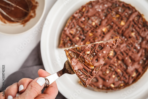 Raw vegan chocolate cake with nuts and chocolate in white plate. Healthy vegan food concept. photo