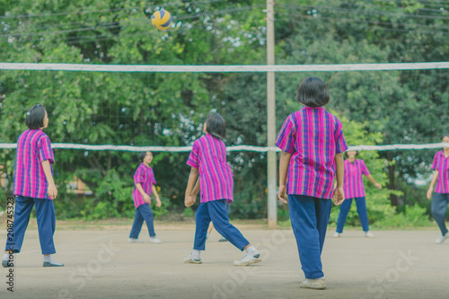 Happiness group of teenage friends playing volleyball in school. © JinnaritT
