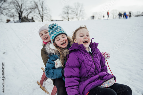 Foto Girls Racing on Sleds in the Snow