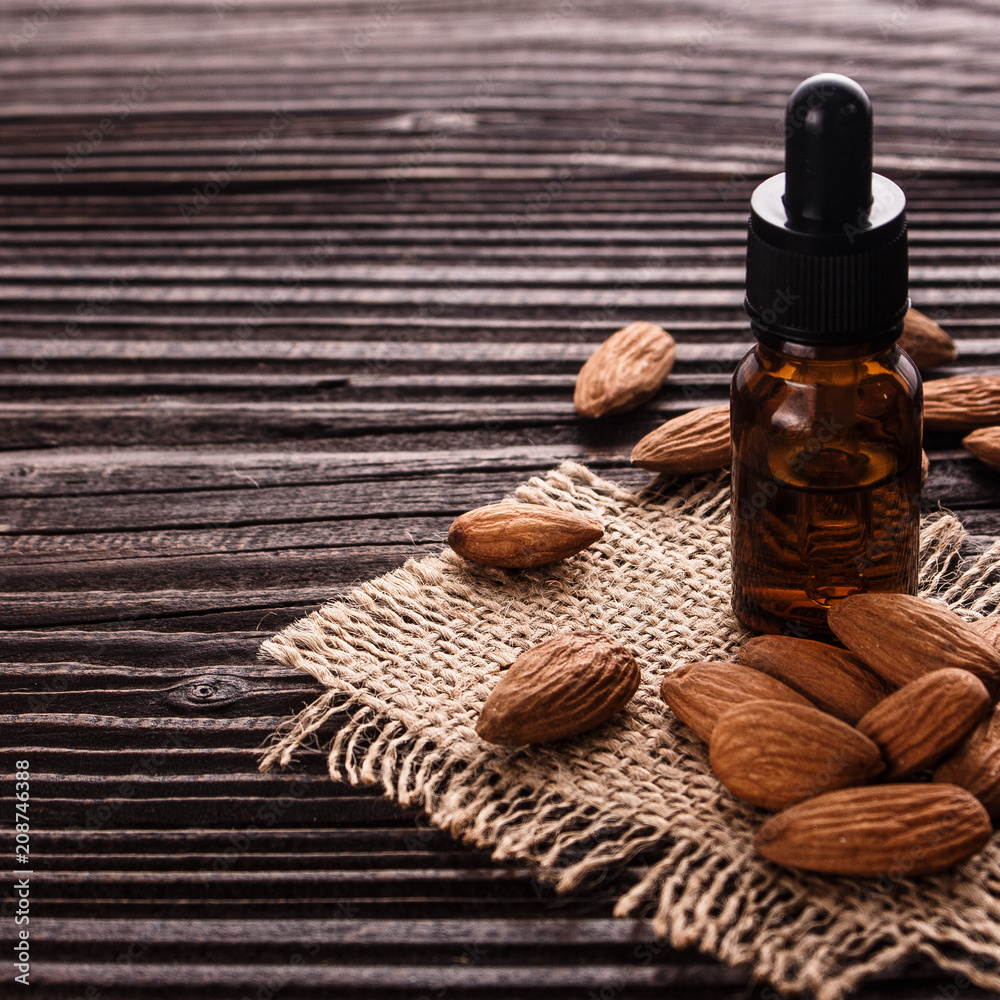 almond essential oil on a wooden background