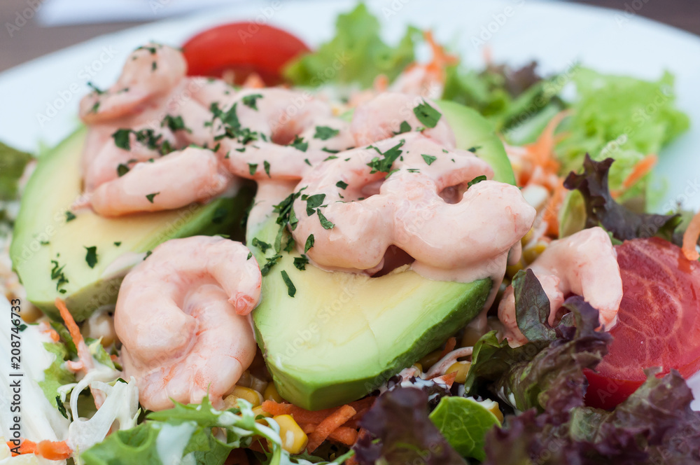 closeup of avocado and shrimps salad in a plate at restaurant
