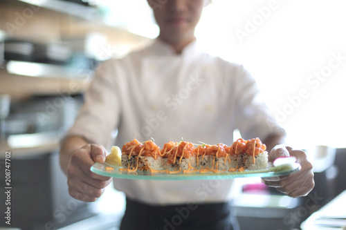 Chef presenting a plate with Salmon's sushi