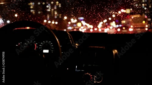 The driver goes through the city at night in rainy weather