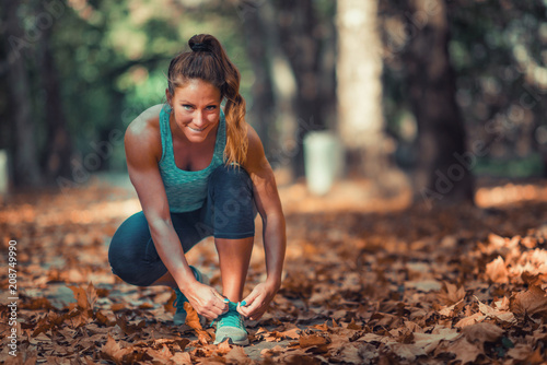 Woman tying shoe in the Park