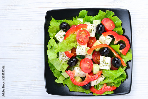 Greek salad on a white wooden background. Space for text or design.