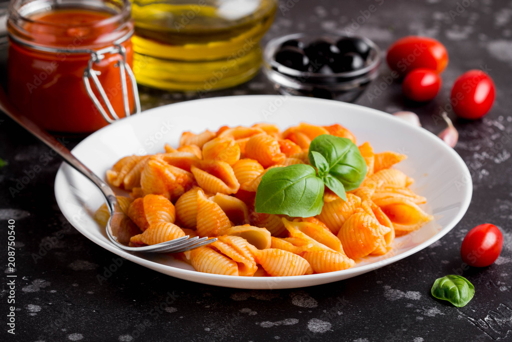 Italian shell pasta with tomato sauce, olives and Basil, classic food Italian shell pasta with tomato sauce, olives and Basil, classic food