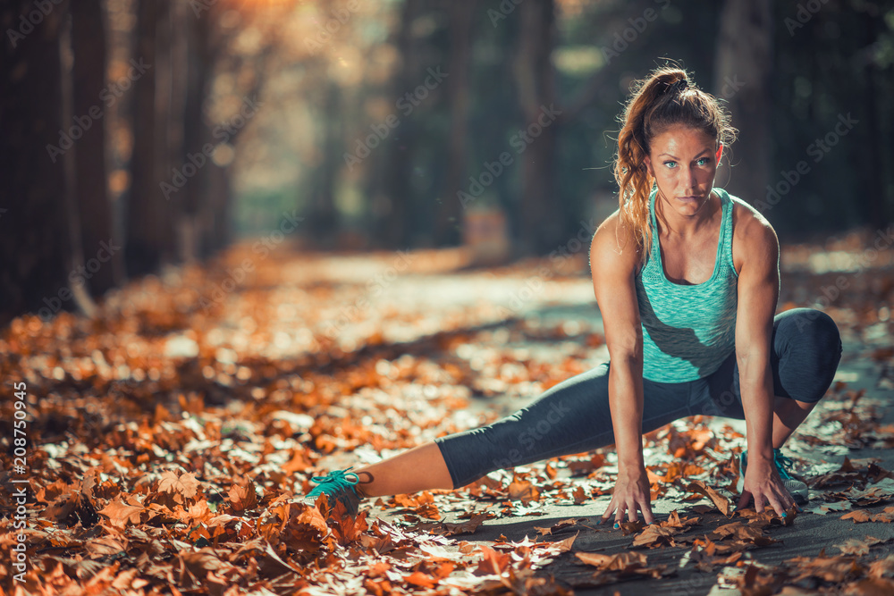 © Microgen - Woman Exercising Outdoors in The Fall