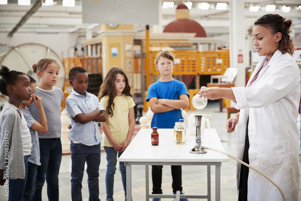Kids watching lab technician carry out a science experiment Kids watching lab technician carry out a science experiment