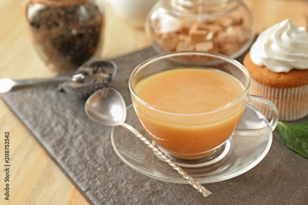 Cup of aromatic tea with milk on slate plate Cup of aromatic tea with milk on slate plate