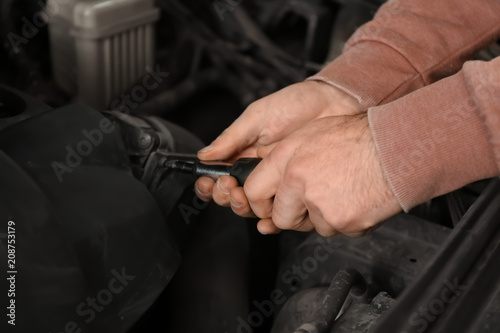 Auto mechanic repairing car in service center  closeup