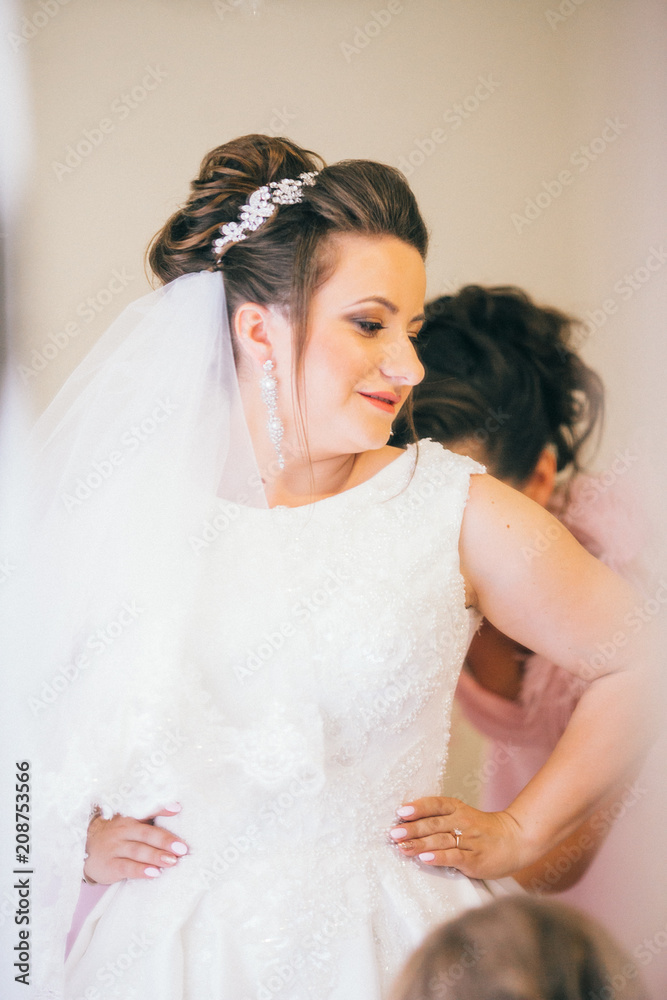 Wedding help. Hands of bridesmaids on bridal dress. Happy marriage and bride at wedding day concept. Bride in white silk robe. Wedding help. Hands of bridesmaids on bridal dress. Happy marriage and bride at wedding day concept. Bride in white silk robe.