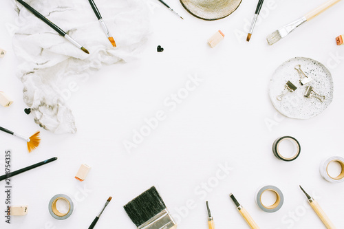 Artist workspace frame of paint brushes and tools on white background. Creative blog template with space for text. Flat lay, top view.