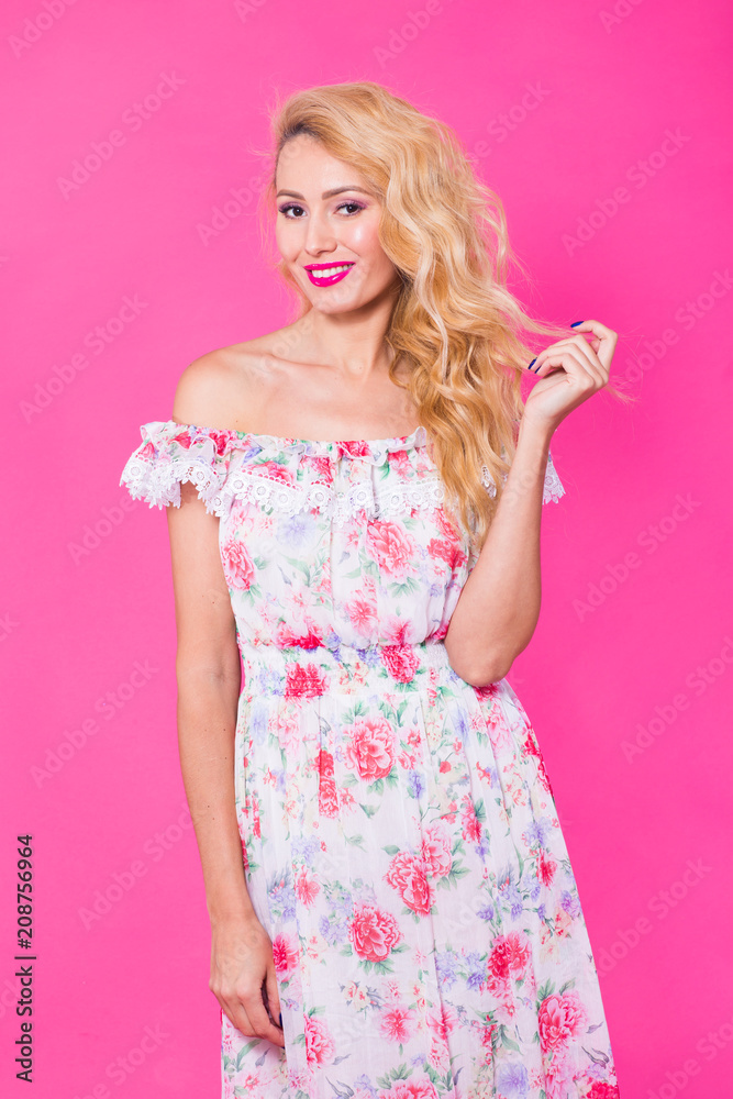 Beautiful girl wearing dress posing on pink background in studio. Summer, holidays and fashion concept Beautiful girl wearing dress posing on pink background in studio. Summer, holidays and fashion concept