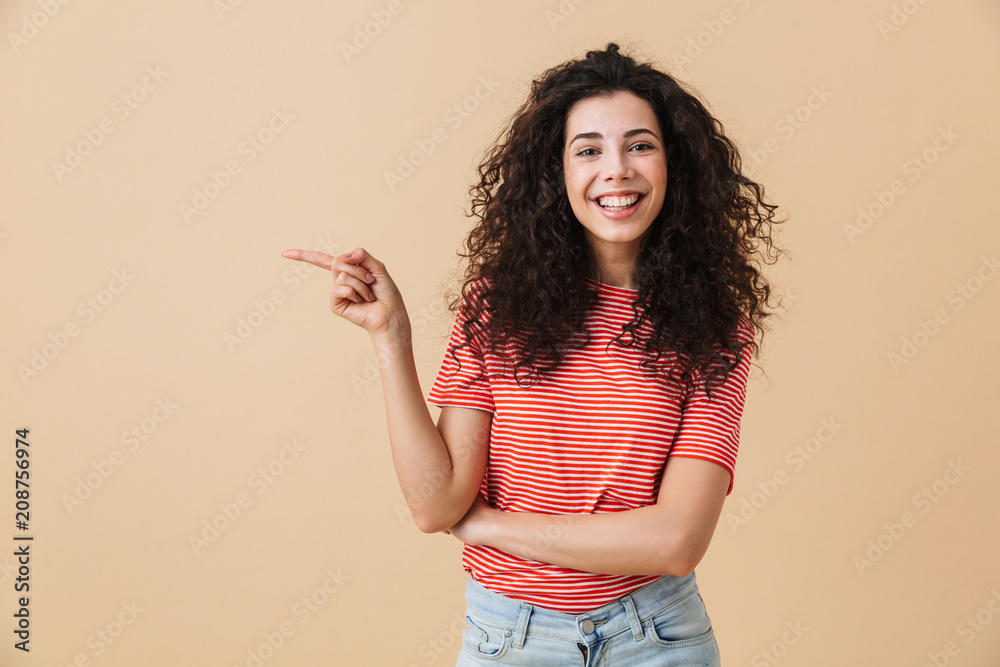 Emotional young woman isolated over beige wall - obrazy, fototapety, plakaty 