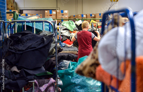 Woman organizes donated clothes at German charity shop