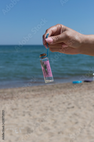 hand holding a bottle with desire on the background of a beautiful sea