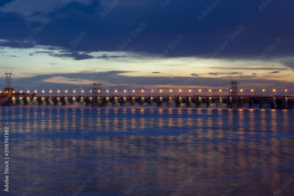 Night photo of the dam, sross water, clouds at sunset, leaden water surface
