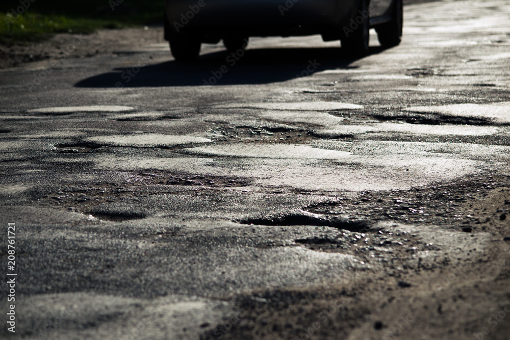 Broken asphalt and car silhouette, soft focus Broken asphalt and car silhouette, soft focus