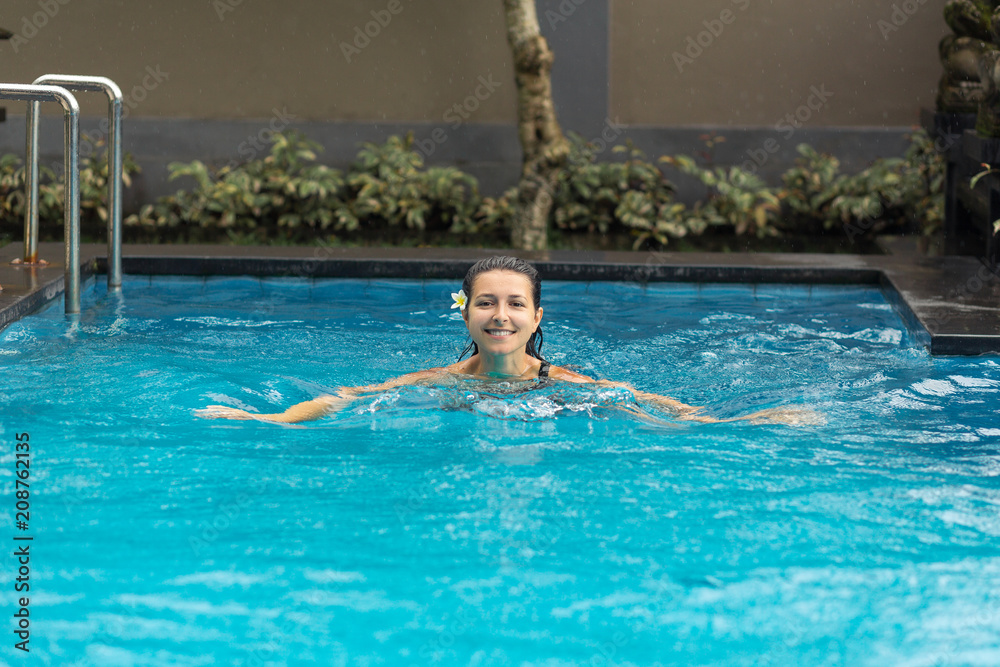 Back of woman with fuit shake in pool