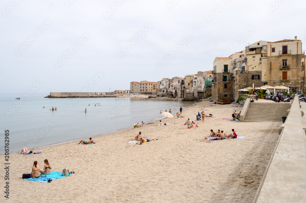 View of the beach of Cefalu with the old city in the background
