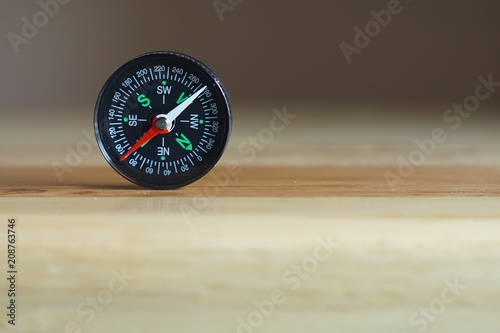 Compass on wooden table, copy space
