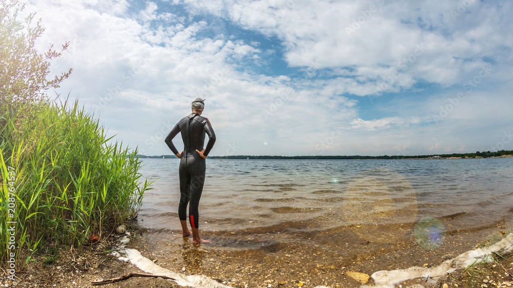 Triathlete standing in a lake before swim