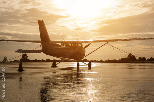 Small Propeller plane park in airport after rain water on floor