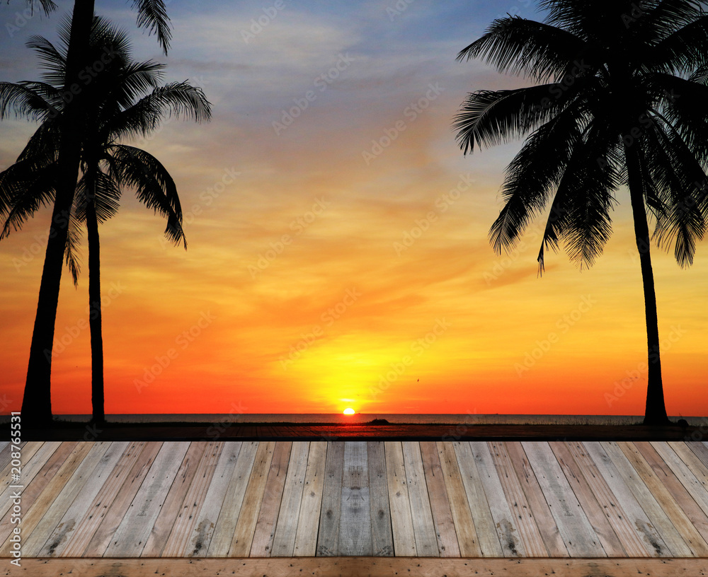 Empty top wooden table on silhouette palm tree on blurry sunset background Empty top wooden table on silhouette palm tree on blurry sunset background