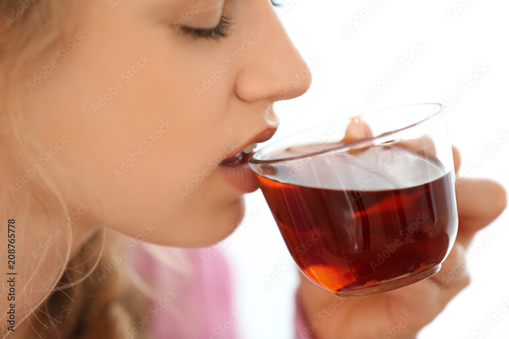 Young woman drinking tea on light background Young woman drinking tea on light background