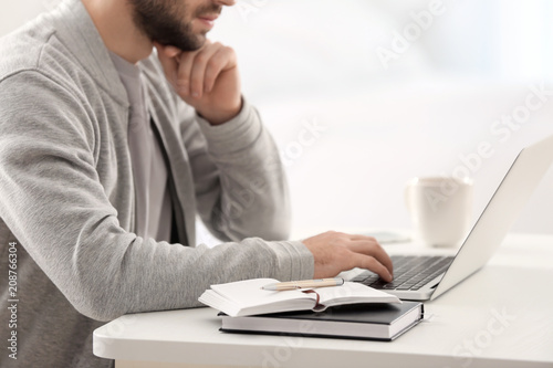 Male freelancer working with laptop in home office