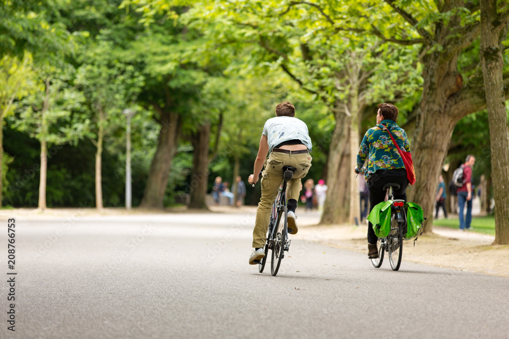 Man and woman biking in the Amsterdam Vondelpark.