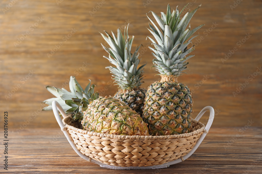 Obraz premium Tasty pineapples in basket on wooden table