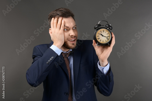 Businessman with alarm cloc...