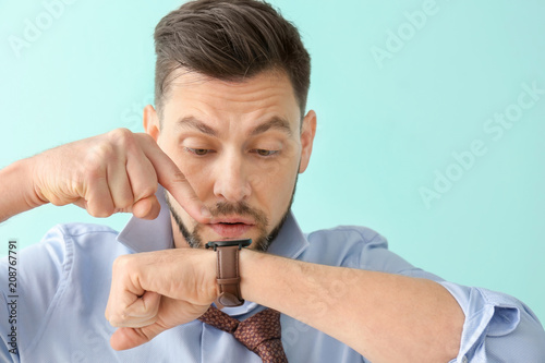 Man looking at wristwatch o...