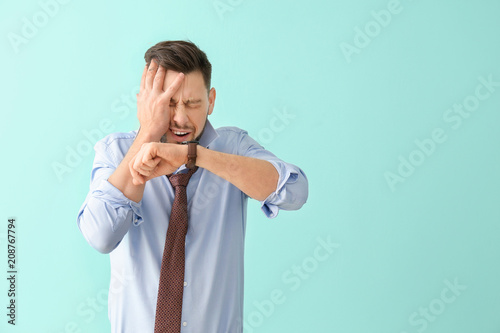 Man looking at wristwatch o...