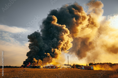 Building fire among fields and huge smoke cloud