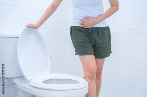 A woman is sitting on toilet with diarrhea or constipated pain concept.