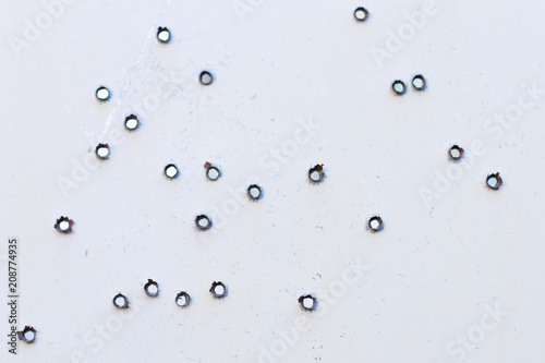 Holes from bullets in metal.