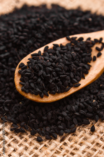 grains of black cumin and oil on the rustic background © Narsil