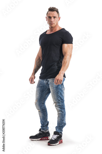 Handsome athletic muscle man in black t-shirt isolated on white, looking at camera